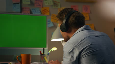 Bearded-guy-listening-music-at-home-closeup.-Man-dancing-head-typing-computer