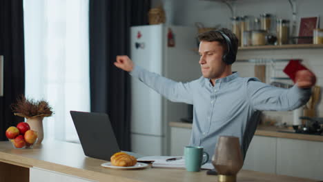 Mann-Hört-Musik-Und-Sucht-Zu-Hause-Auf-Dem-Laptop-Informationen.-Typ-Verwendet-Kopfhörer.