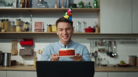 Man-celebrating-birthday-cake-alone-greeting-friends-on-online-meeting-close-up.