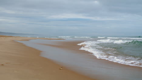 Olas-Lavando-La-Orilla-Del-Océano-En-La-Vista-Vertical-De-Un-Día-Sombrío.-Lugar-Tranquilo-Tipo-Zen