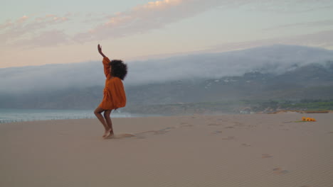 Modern-dancer-moving-sand-seashore-at-cloudy-evening.-Woman-dancing-on-beach.