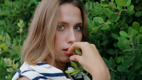 Girl-posing-green-leaves-bushes-background-portrait.-Charming-woman-relaxing