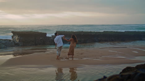 Hermosa-Pareja-Disfruta-De-La-Playa-Del-Mar.-Gente-Feliz-Girando-Regocijándose-Vista-Vertical.