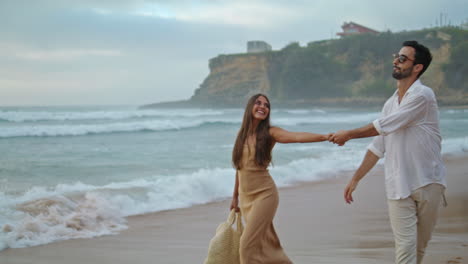 Happy-lovers-walking-sea-beach-outdoors.-Hispanic-couple-enjoying-ocean-coast