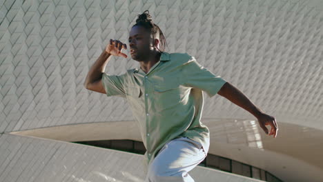 Young-man-moving-flexibly-at-city-vertically-closeup.-Guy-dancing-choreography