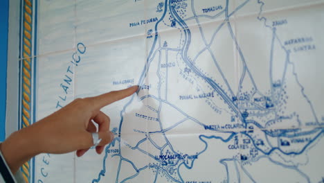Closeup-finger-pointing-map-looking-trip-direction.-Lost-tourist-planning-route