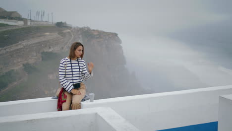 Chica-Relajante-Ciudad-Costera-Con-Café-Matutino-Vertical.-Turista-Admira-Pintoresco