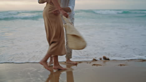 People-feet-walking-sand-beach-at-vacation.-Unrecognizable-couple-stepping-shore