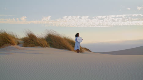 Woman-mirror-standing-sand-desert-summer-evening.-Girl-posing-in-front-gray-sky.