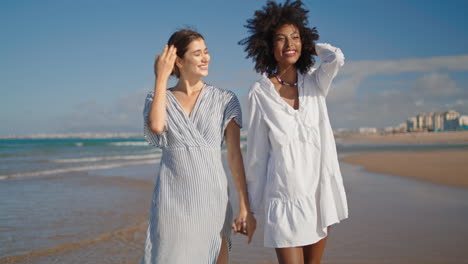 Pareja-Lgbt-Tomados-De-La-Mano-Caminando-Por-La-Playa-Del-Océano.-Feliz-Relación-De-Pareja-De-Lesbianas