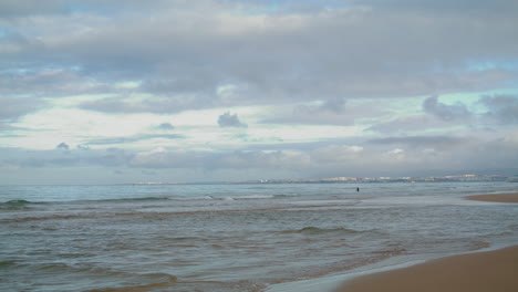 Olas-Del-Mar-Golpeando-La-Playa-Bajo-El-Cielo-Nublado.-Costa-Oceánica-Pacífica-Con-Ondulaciones