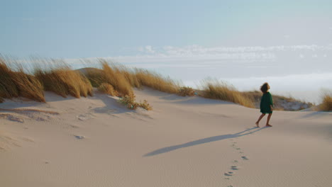 Unknown-girl-walking-desert-leaving-footprints-on-sand.-Woman-stepping-on-dunes.