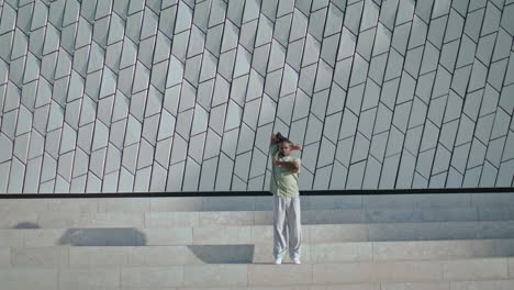 Athletic-man-moving-hands-stairs-vertical-shot.-Fashion-guy-showing-modern-dance