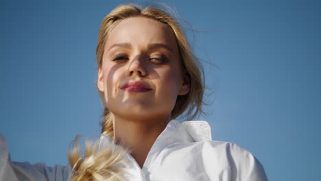 Blonde-Frau-Sonnenlicht-Porträt.-Vertikale-Lächelnde-Dame-Gesicht-Sonnenstrahlen-Blauer-Himmel