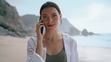 Girl-talking-smartphone-seashore-close-up.-Woman-calling-phone-standing-on-beach