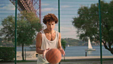 Contemporary-student-throwing-ball-at-stadium-closeup.-Young-man-playing-alone