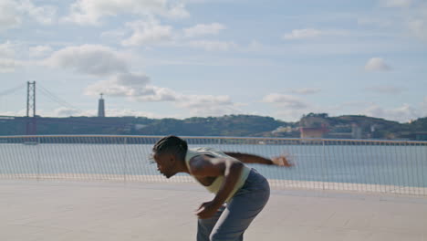 Flexible-dancer-practising-choreography-at-sea-background.-Muscular-guy-dance