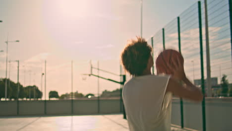 Chico-Deportivo-Jugando-Baloncesto-En-Primer-Plano-De-La-Luz-Del-Sol.-Entrenamiento-De-Salto-Adolescente