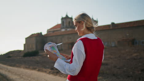 Satisfied-woman-taking-photos-at-old-village.-Cheerful-tourist-making-pictures