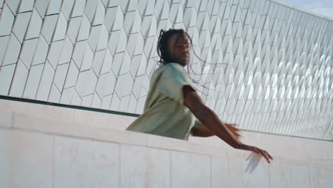 Flexible-man-dancing-urban-wall-passionately.-Black-hair-dancer-moving-closeup