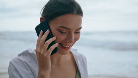 Smiling-girl-calling-beach-closeup.-Woman-talking-by-smartphone-walking-seashore