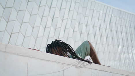 Dreadlocks-man-dancing-abstract-wall-vertical-portrait.-Guy-touching-building