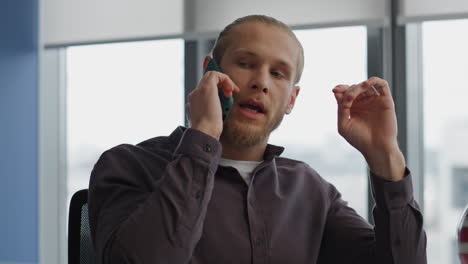 Nervous-guy-chatting-cellphone-remote-office-close-up.-Stressed-startuper-call