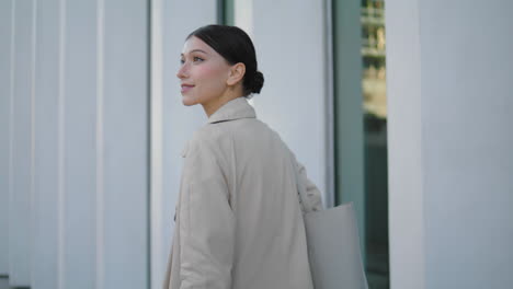 Happy-carefree-girl-walking-city-streets-in-coat-closeup.-Woman-smiling-vertical