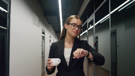 Glückliches-Mädchen,-Das-Morgens-Durch-Den-Bürokorridor-Geht.-Lächelnder-Manager,-Der-Eine-Kaffeetasse-Hält