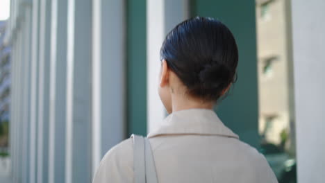 Back-view-walking-woman-straightening-hairstyle-close-up.-Girl-hurrying-on-work.