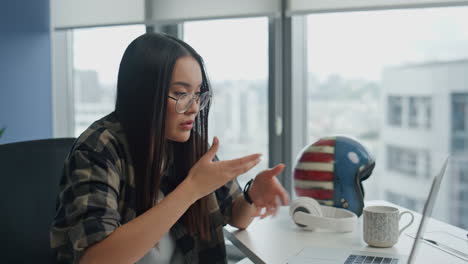 Serious-specialist-video-calling-computer-home-close-up.-Woman-gesturing-hands