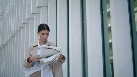 Busy-woman-reading-newspaper-going-for-work.-Lady-walking-with-press-vertically