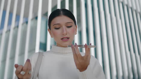 Woman-talking-phone-microphone-standing-in-front-modern-city-building-close-up.