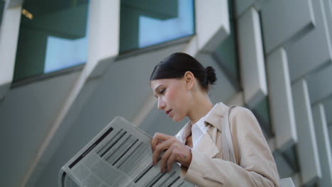 Mujer-Pasando-Las-Páginas-Del-Periódico-Parada-Al-Aire-Libre-De-Cerca.-Mujer-De-Negocios-Leyendo