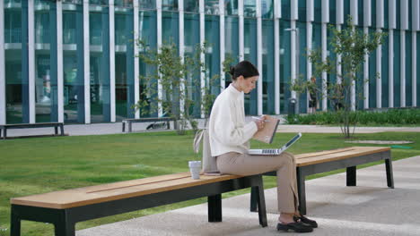 Estudiante-Escribiendo-Diploma-Portátil-Sentado-Banco-Cerca-De-La-Universidad.-Sinopsis-Del-Trabajo-De-Chicas