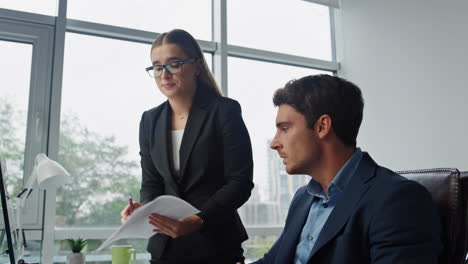 Nervous-worker-reporting-boss-in-office.-Angry-executive-shouting-throw-papers