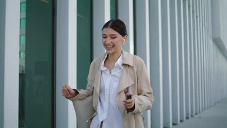 Frau-Ruft-Mit-Kabellosen-Ohrhörern-An-Und-Geht-Auf-Einer-Stadtstraße-Spazieren.-Mädchen-Spricht-Per-Smartphone.