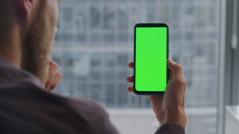 Closeup-mockup-cellphone-man-arms.-Startuper-holding-chroma-key-mobile-at-home