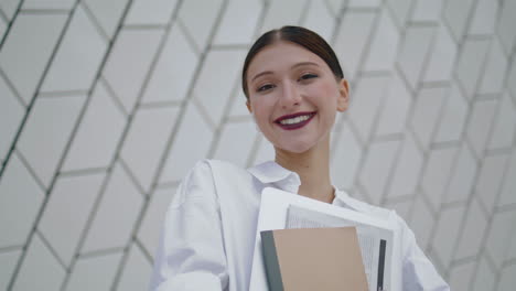 Portrait-happy-professional-manager-posing-in-front-modern-building-vertical