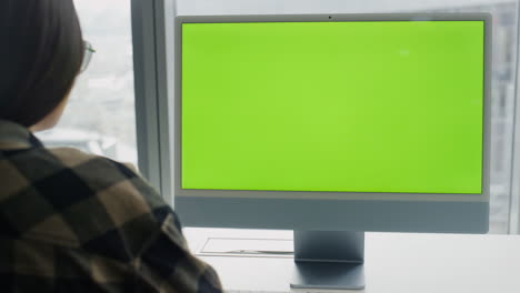 Woman-reading-chromakey-computer-at-city-view-flat.-Student-watching-monitor