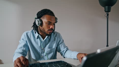 Creative-guy-typing-console-indoors-closeup.-Black-hair-sound-engineer-mixing