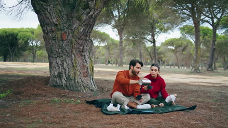 Couple-travelers-sitting-blanket-autumn-nature-vertical.-Family-romantic-picnic.