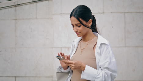 Glückliches-Mädchen-Messaging-Smartphone-Straße-Vertikale-Nahaufnahme.-Lächelnde-Dame-SMS