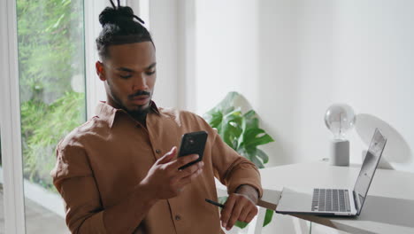 Serious-man-reading-cellphone-message-in-apartment-closeup.-Guy-looking-screen