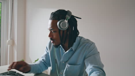 Focused-dj-playing-music-flat-remotely-closeup.-Serious-man-working-controller