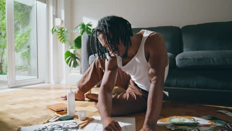 Contemporary-man-painting-paper-at-apartment-closeup.-Black-hair-guy-leisure