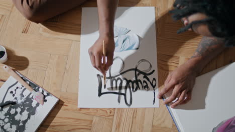 Artist-hands-painting-paper-light-apartment-top-view.-Guy-improving-art-skills