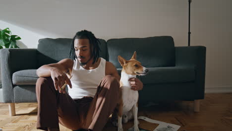 Hombre-Positivo-Posando-Zoom-En-Casa-De-Mascotas.-Chico-Afroamericano-Abrazando-A-Un-Perro-Bostezando