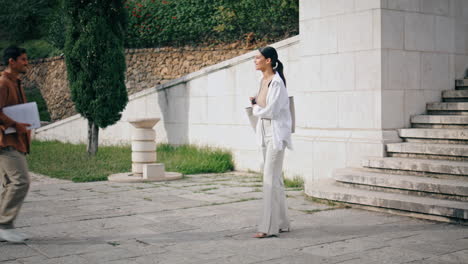 Mujer-De-Negocios-Hablando-Por-Teléfono-Solo-En-La-Plaza.-Startups-Dándose-La-Mano-Saludo