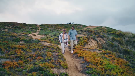 Couple-tourists-walking-hill-holding-hands-vertical.-Family-pair-enjoy-vacation